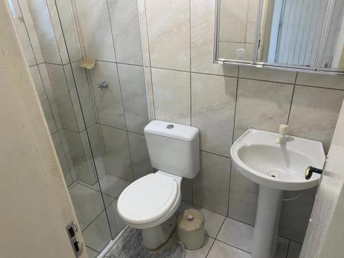 a bathroom with a toilet and a sink at Ares de Salinas - 100 metros da praia in Cidreira