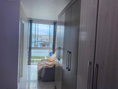 a room with a door to a room with a window at Ares de Salinas - 100 metros da praia in Cidreira