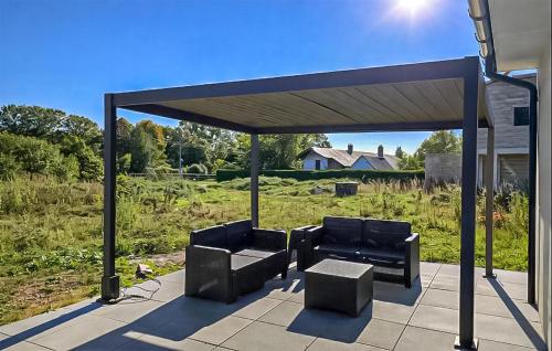 - un pavillon avec 2 chaises et une table sur la terrasse dans l'établissement Maison Campagne Normandie, à Ry