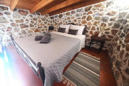een slaapkamer met een bed in een stenen muur bij Markos House in Kalymnos