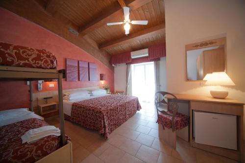a hotel room with two beds and a mirror at Hotel Derby in Riccione