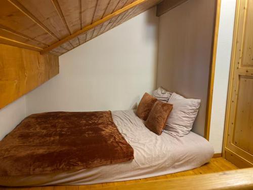 a bed with two pillows on it in a bedroom at Studio Belle Neige in Bernex