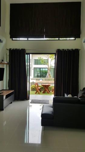 a living room with a couch and a large window at Shalom Casa Seaside Rayong in Ban Chak Phai