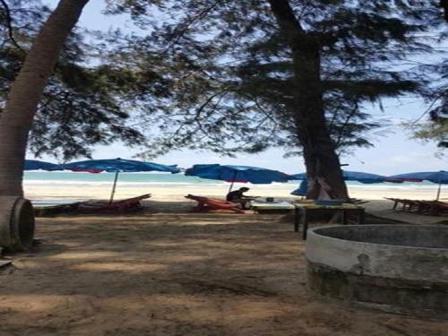 a beach with umbrellas and chairs on the beach at Shalom Casa Seaside Rayong in Ban Chak Phai