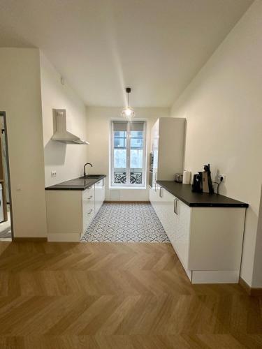 Apartment T2 في سيت: مطبخ بخزائن بيضاء وطاولة عمل