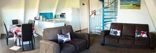 a living room with two chairs and a kitchen at Island Breeze Motel in Currie