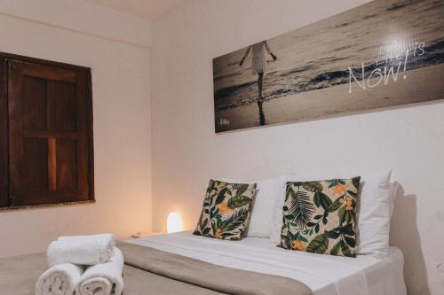 een slaapkamer met een bed met witte lakens en kussens bij Che Lagarto Hostel Itacaré in Itacaré