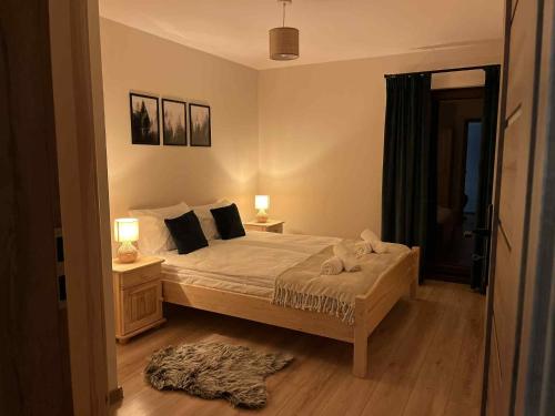 a bedroom with a bed with two tables and two lamps at Apartament Górska Przystań Kluszkowce in Kluszkowce