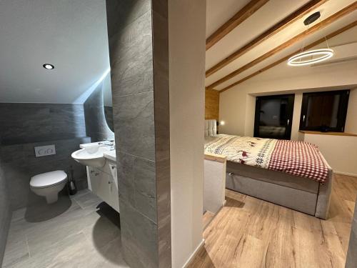 ein Badezimmer mit Bett, Waschbecken und Toilette in der Unterkunft Tiny House IBEX in Saas-Fee