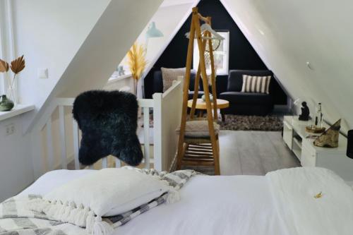 a bedroom with a bed and a staircase with a chair at Forest Inn in Ugchelen
