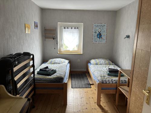 een kleine kamer met twee bedden en een raam bij Ferienwohnung Marienhof OG in Seelbach