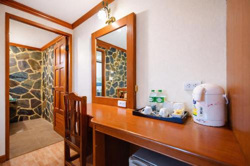 een keuken met een houten aanrechtblad met een spoelbak en een spiegel bij Tiger Complex Hotel in Patong Beach