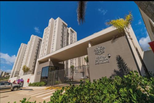 un edificio con alti edifici bianchi in un parcheggio di Apartamento proximo centro a Poços de Caldas