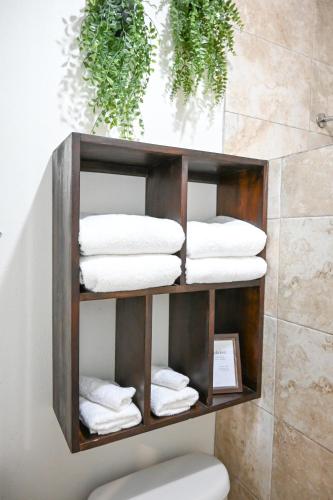 a wooden shelf with folded towels in a bathroom at The Palapa House in San Pedro