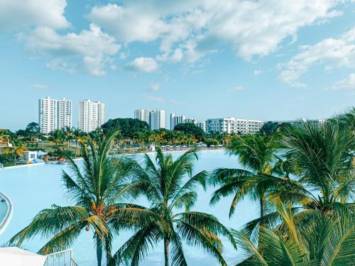 ein Pool mit Palmen vor einer Stadt in der Unterkunft Ocean Breeze Apartment in Playa Blanca