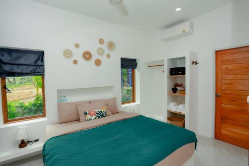 a bedroom with a bed with a green blanket at Neverland in Ban Tai