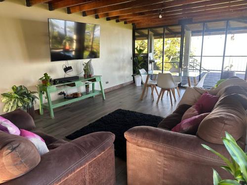 een woonkamer met twee bruine banken en een tafel bij San Vicente Mountain in Colón