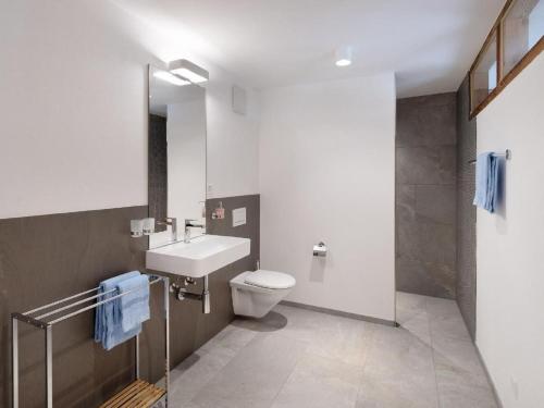 a bathroom with a toilet and a sink at Apartment Bellezza - Bio Bergün by Interhome in Bergün