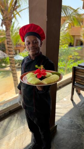 Een man houdt een bord eten vast. bij Di Milo Boutique Hotel in Kiwengwa