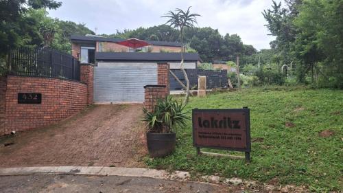 a house with a sign in front of it at Lakritz A Place of Experience through Art in Chintsa