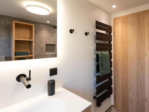 a bathroom with a sink and a mirror at Chalet Emely in Bartholomäberg