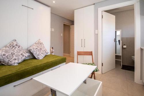 een woonkamer met een bank en een tafel bij SeaPoint MicroStudio - Walk 2 Promenade&Waterfront in Kaapstad