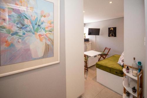 een kamer met een schilderij van een vaas aan de muur bij SeaPoint MicroStudio - Walk 2 Promenade&Waterfront in Kaapstad