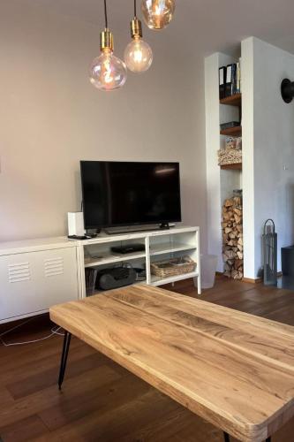 a living room with a tv and a wooden coffee table at Apartment Chasa Ernst by Interhome in Zernez