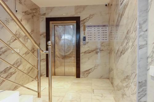 een lift in een badkamer met marmeren muren bij Najd Cozy Apartment in Dammam