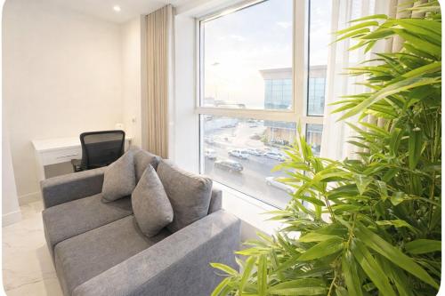 un soggiorno con un divano e una grande finestra di Najd Cozy Apartment a Dammam