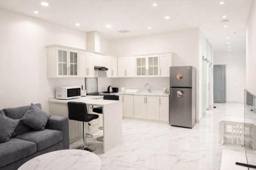 een keuken en een woonkamer met een bank en een koelkast bij Najd Cozy Apartment in Dammam