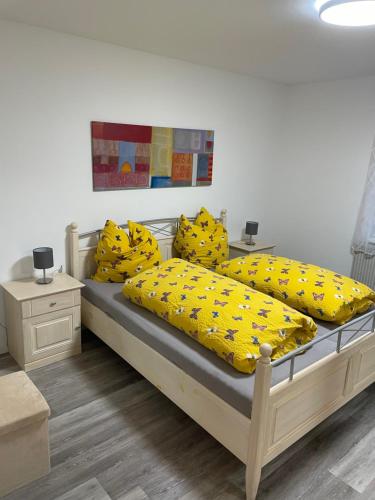a bedroom with two beds with yellow sheets and pillows at Ferienwohnung Traumschleife Klettersteig in Boppard