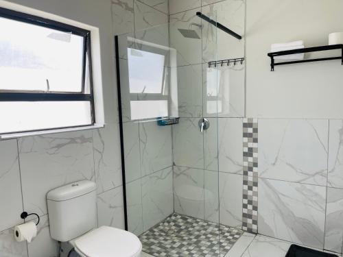 a bathroom with a shower and a toilet at Maita Corner in Monte Vista
