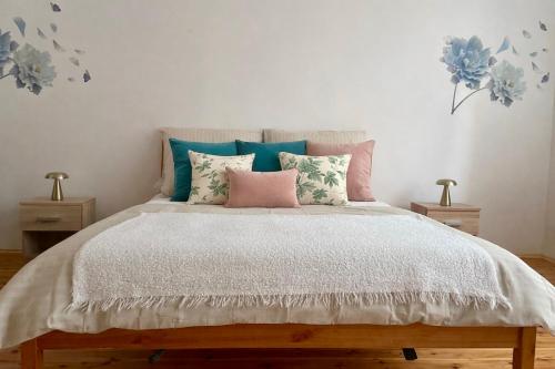 een slaapkamer met een bed met roze en blauwe kussens bij Amrita in Golčŭv Jeníkov