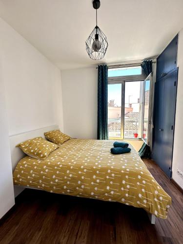 Appartement T3 في سيت: غرفة نوم بها سرير ذو ملاءات صفراء ونافذة