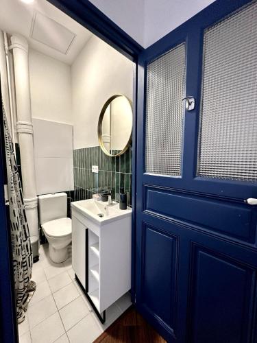 Appartement T3 في سيت: حمام بباب أزرق ومرحاض ومغسلة
