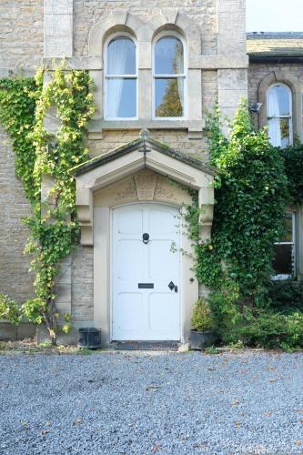 a white garage door on a brick building at Nent Hall Country House Hotel in Nenthead