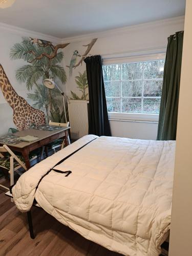 a bedroom with a bed and a desk and a window at Studio le Memagne WiFi gratuit in Lacuisine