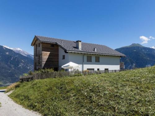 a house on a hill with mountains in the background at Apartment Hof Quadra by Interhome in Flerden