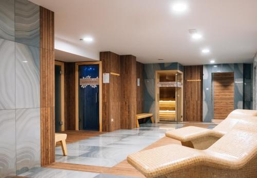una camera con pareti in legno, divano e sedie di Hotel Cztery Pory Roku BUSINESS & SPA a Bielsk Podlaski