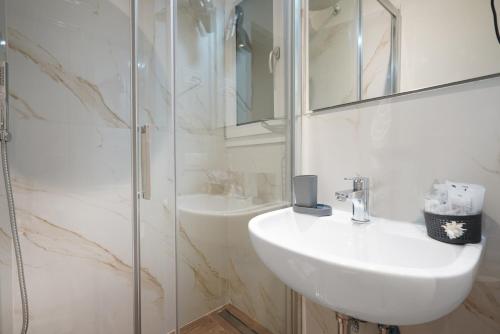 een witte badkamer met een wastafel en een douche bij B&B Le Stanze del Duomo in Florence