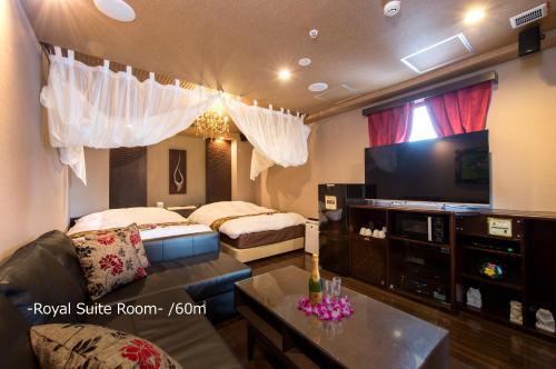 a living room with two beds and a flat screen tv at Hotel Pasela no mori Yokohama Kannai in Yokohama