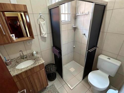 een badkamer met een douche, een toilet en een wastafel bij Casa aconchegante perto do mar em Imbé in Imbé