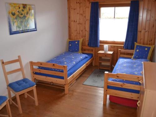 a room with two beds and a chair and a window at Apartment Wohnung Bellevue by Interhome in Chevenez