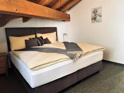 a large bed in a room with a wooden ceiling at Apartment La Stüerta by Interhome in Pontresina