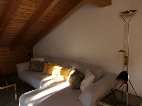 a white couch with pillows on it in a room at Apartment La Stüerta by Interhome in Pontresina