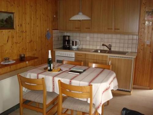 a kitchen with a table with chairs and a sink at Apartment Chalet Bärli by Interhome in Fiesch
