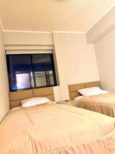 two beds in a room with a window at Brand New Apartment in Lima