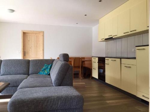 a living room with a couch and a kitchen at Apartment Schwändelifluh by Interhome in Flühli