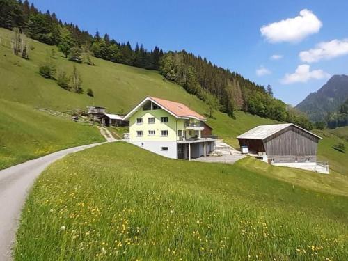a house on a hill next to a road at Apartment Schwändelifluh by Interhome in Flühli